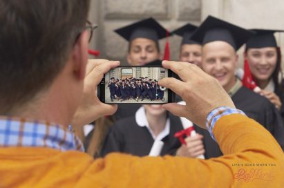 A man taking a photo of a group of graduates with the LG V20’s Wide Angle camera