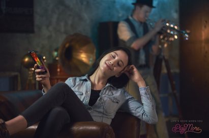 A woman reclining in a chair listening to music via headphones with the LG V20’s Hi-Fi Quad DAC