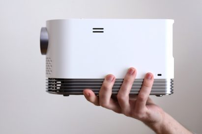 Side view of LG PROBEAM LASER PROJECTOR (MODEL HF80J) lifted by a man's hand