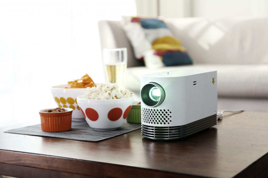 Front view of the LG Probeam Laser Projector (model HF80J) facing 15 degrees to the left on a table with snacks in bowls
