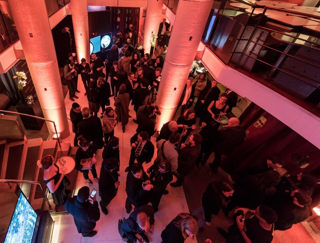 Several visitors conversing and enjoying complementary beverages inside LG SIGNATURE Gallery