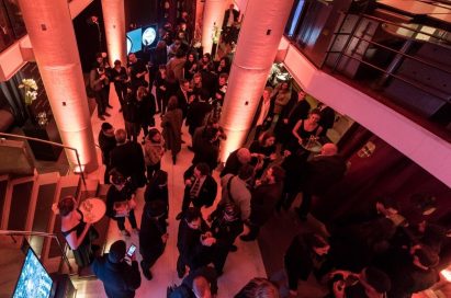 Several visitors conversing and enjoying complementary beverages inside LG SIGNATURE Gallery