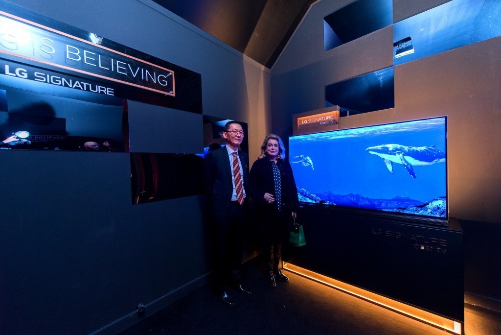 Visitors standing before a display at the LG SIGNATURE Gallery launch event in Paris