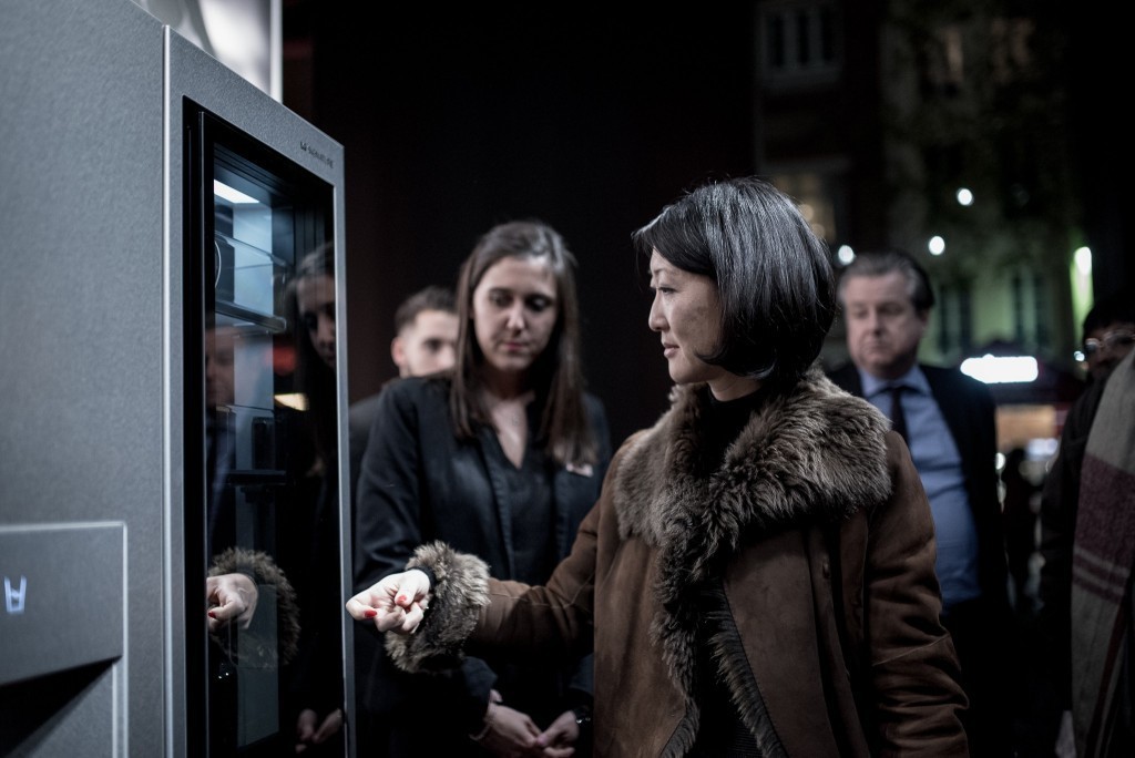 A visitor touches LG SIGNATURE InstaView™ Door-in-Door™ Refrigerator