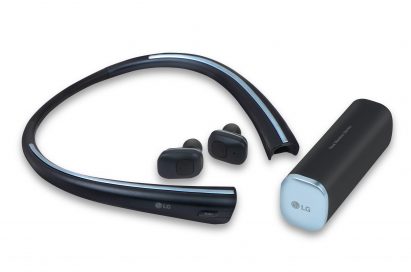 The front left view of the LG Tone Free with the wireless earbuds extracted from the neckband and the optional charging cradle on the right
