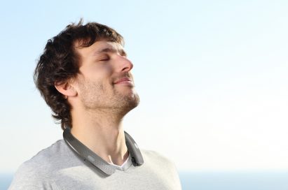 A man looking toward the sky with the LG Tone Studio around his neck