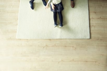 A family sits in their living room looking at the LG SIGNATURE OLED TV W, which hung flush against the wall