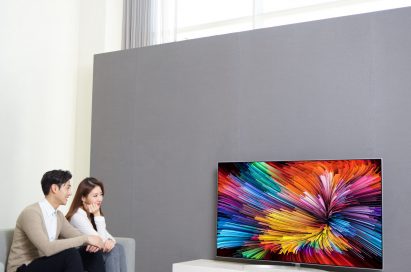 Another view of a couple sitting on a couch watching the LG SUPER UHD TV (model SJ95)