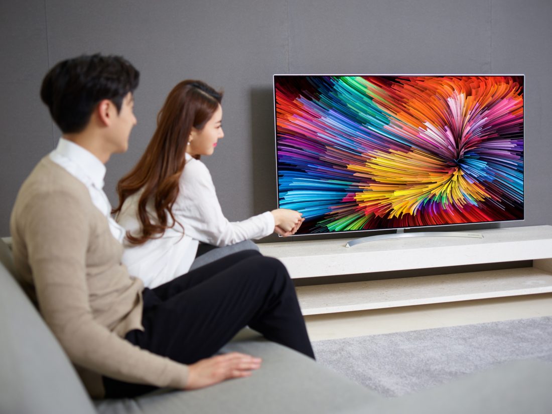 The last image of a couple sitting on a couch watching the LG SUPER UHD TV (model SJ95)