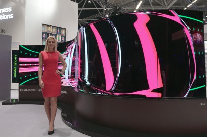 A model standing on the left side of LG’s 65-inch Dual-View Curved Tiling OLED signage