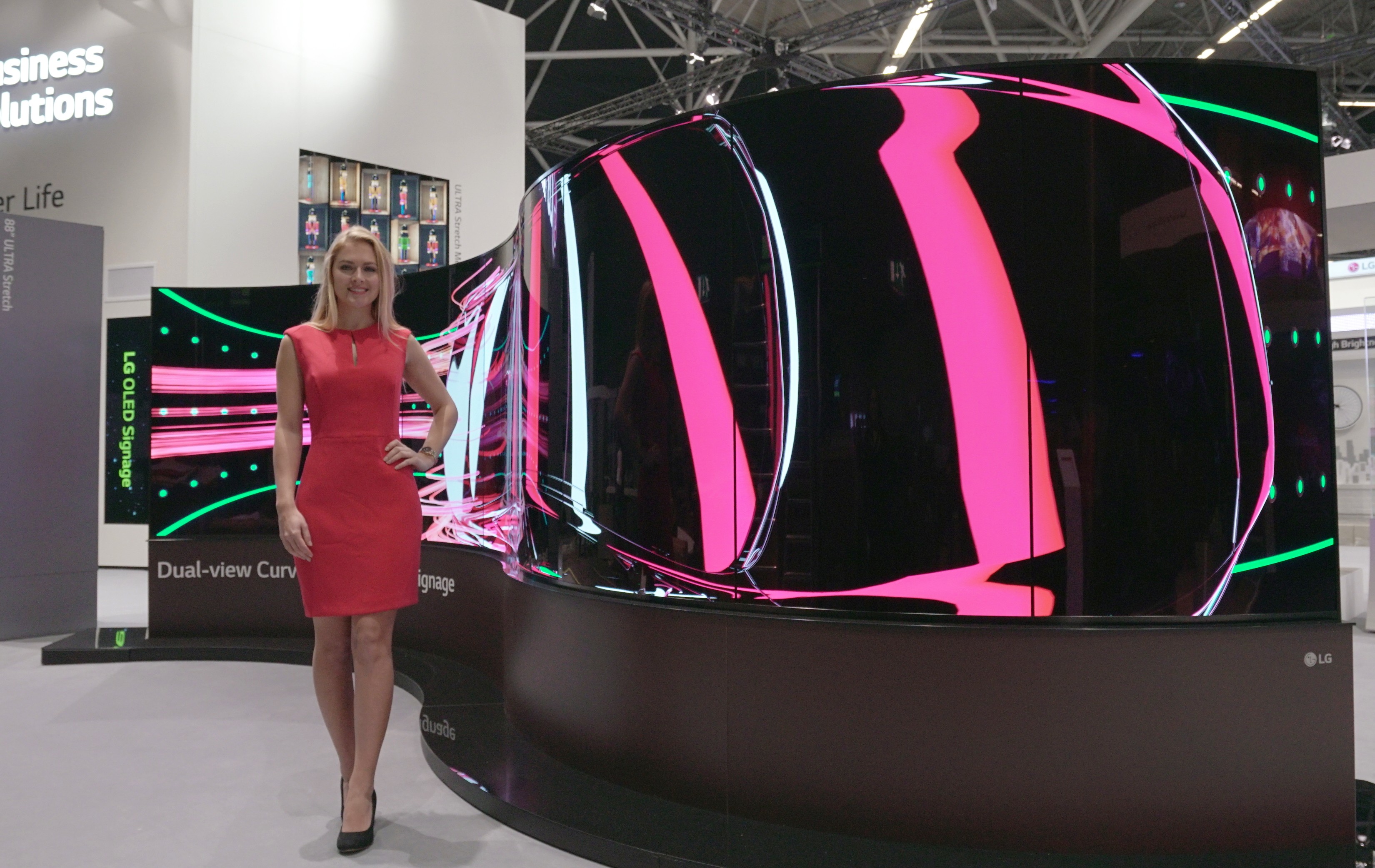 A model standing on the left side of LG’s 65-inch Dual-View Curved Tiling OLED signage