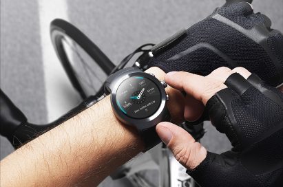 A man touching his LG Watch Sport in Titanium while taking a break from cycling