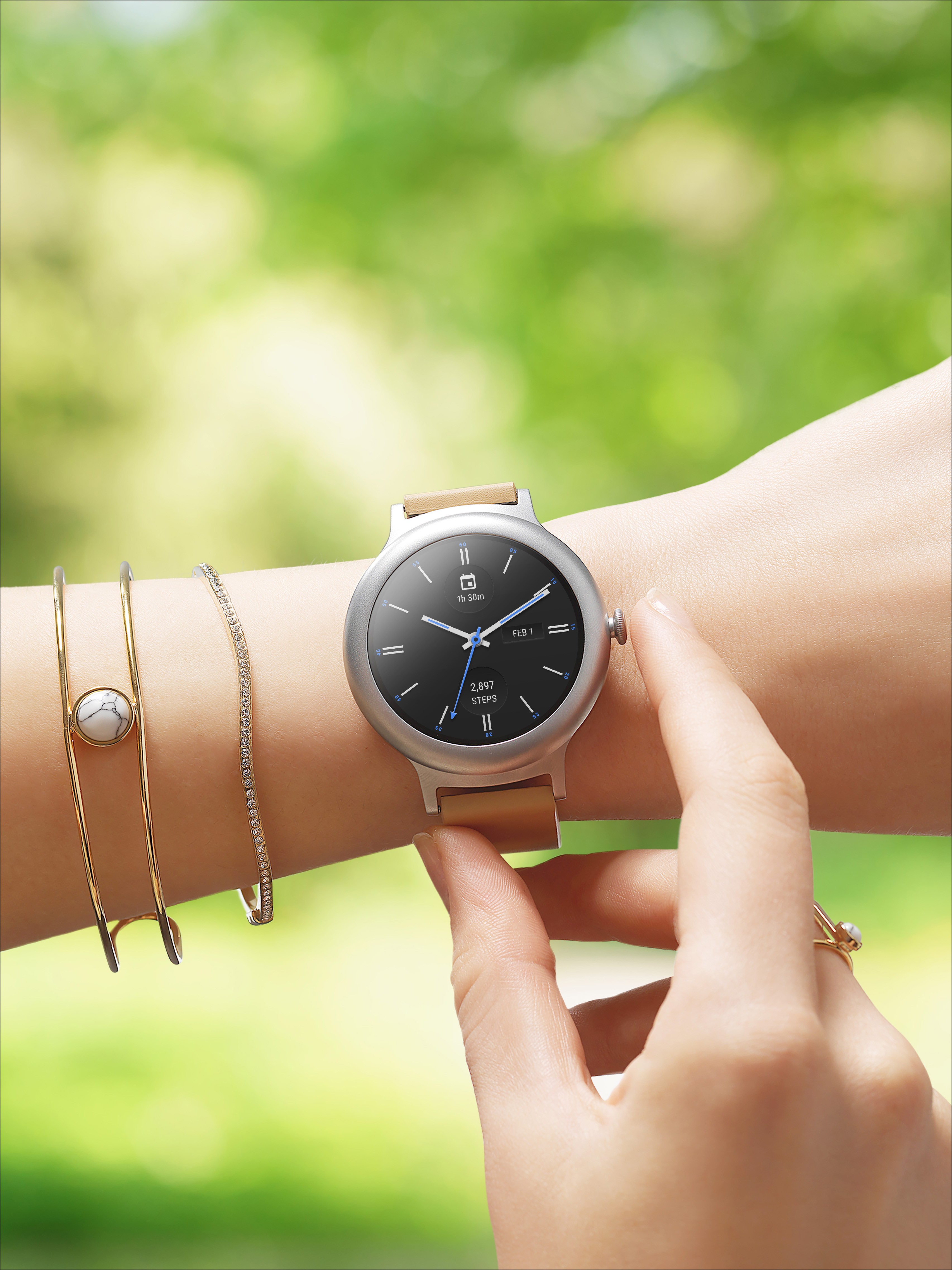 A woman touches the LG Watch Style in Rose Gold around her wrist