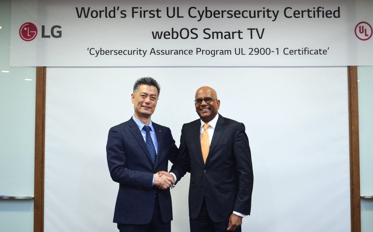 Hwang Jeong-hwan, head of R&D Laboratory of Home Entertainment at LG Electronics, shakes hands with Sajeev Jesudas, CEO of consumer business at Underwriters Laboratories