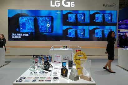 Two LG G6 devices and 31 booth awards given to the LG G6 at MWC 2017 in front of a screen showing off LG G6’s dual wide-angle cameras