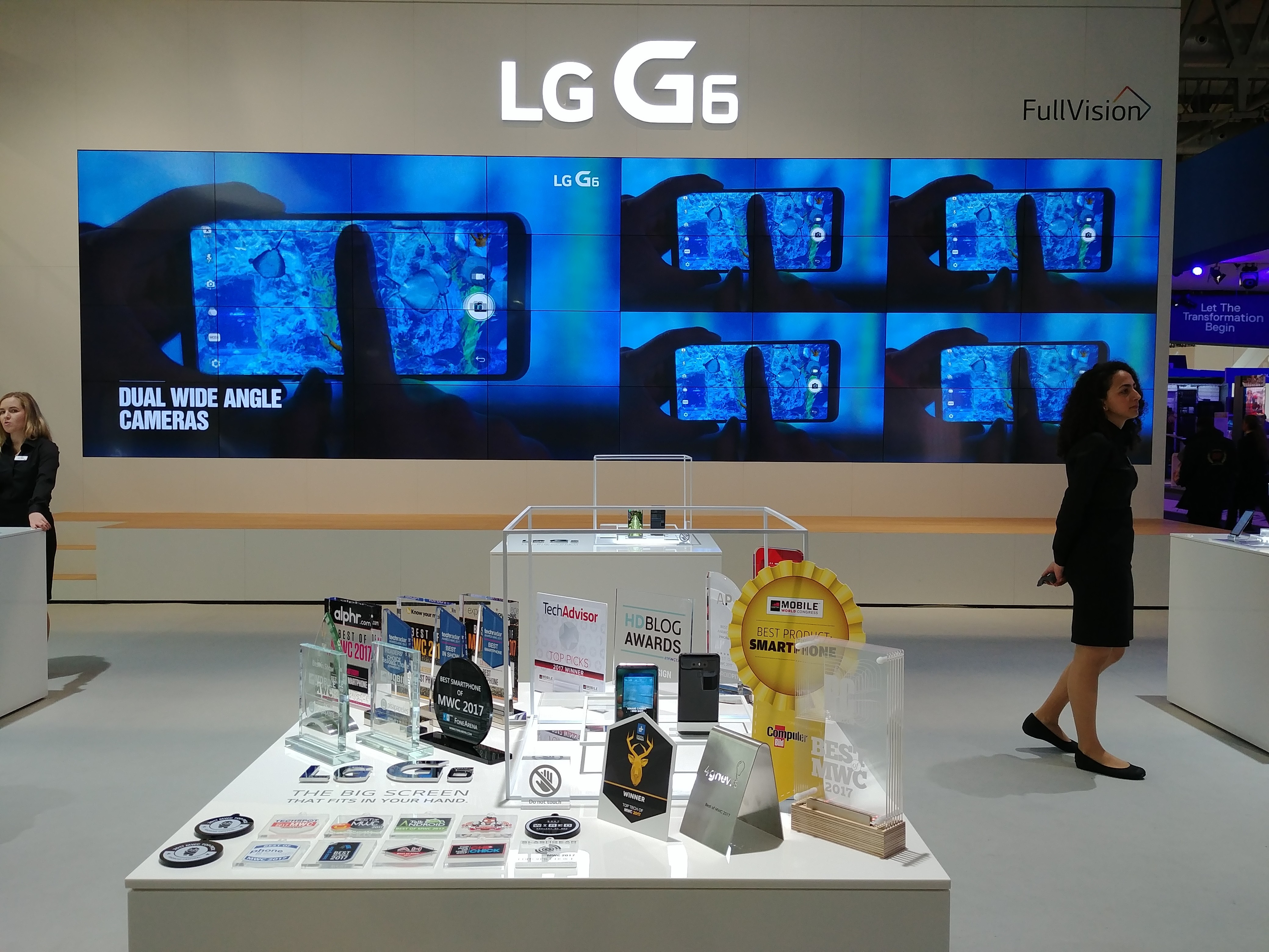 Two LG G6 devices and 31 booth awards given to the LG G6 at MWC 2017 in front of a screen showing off LG G6’s dual wide-angle cameras