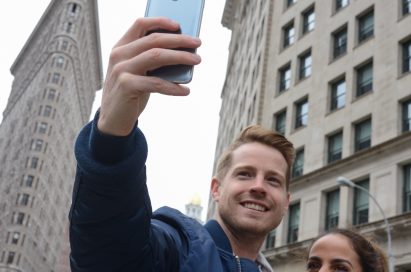 A man and woman take a selfie with the LG G6 in Ice Platinum in front of the Flatiron Building in New York, USA