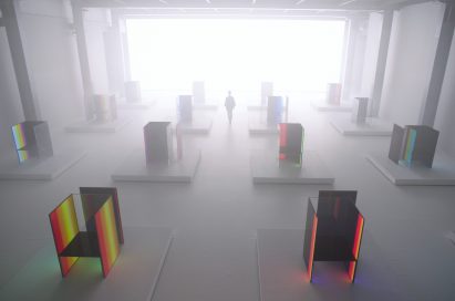 A woman walk around Tokujin Yoshioka’s art exhibition hall which is blurred by the fog effect.