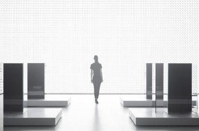 A woman is seen in the background walking beside the back wall of Tokujin Yoshioka’s art exhibition, which boasts thousands of bright lights.