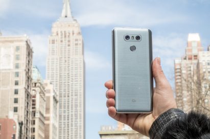 A person holds the LG G6 in Ice Platinum in front of the Empire State Building in New York, USA, showing off the back side of the device