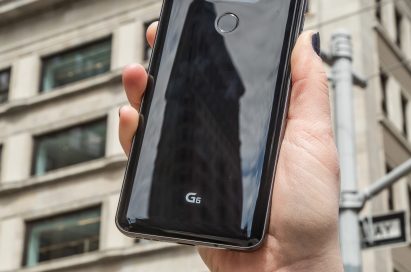 A person holds the LG G6 in Astro Black up in front of a New York building, showing off the back side of the device