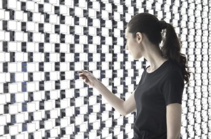 A woman takes a closer look at the back wall of Tokujin Yoshioka’s art exhibition, which boasts thousands of bright lights.
