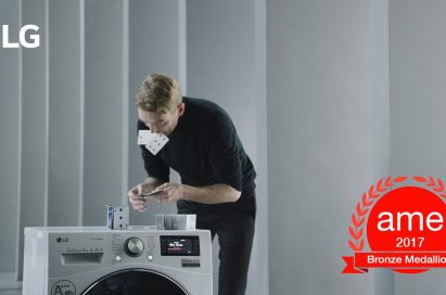 A professional card stacker Bryan Berg building house of card atop an LG Centum System™ washing machine with AME Award 2017 logo featured