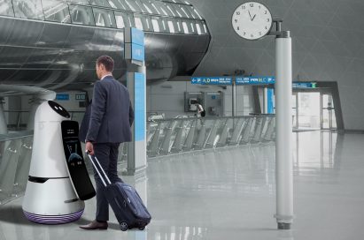 A man checking in at the airport with the help of the LG Airport Guide Robot.