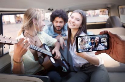 A person taking a picture with the LG Q6 of band member inside a van