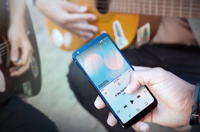 A person playing a song on the LG G6 via speakers