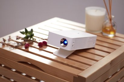 The LG MiniBeam Projector model PH30J on a wooden stool