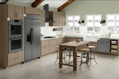 Kitchen with wooden cabinets and the complete North American LG STUDIO lineup with black stainless steel finish, including oven, induction stovetop, wall hood, dishwasher and Side-by-Side refrigerator.
