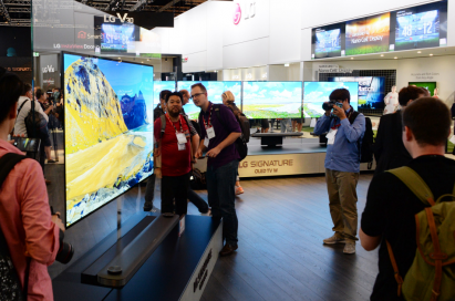 Visitors to LG IFA booth examining the minimal depth of LG SIGNATURE OLED TV W