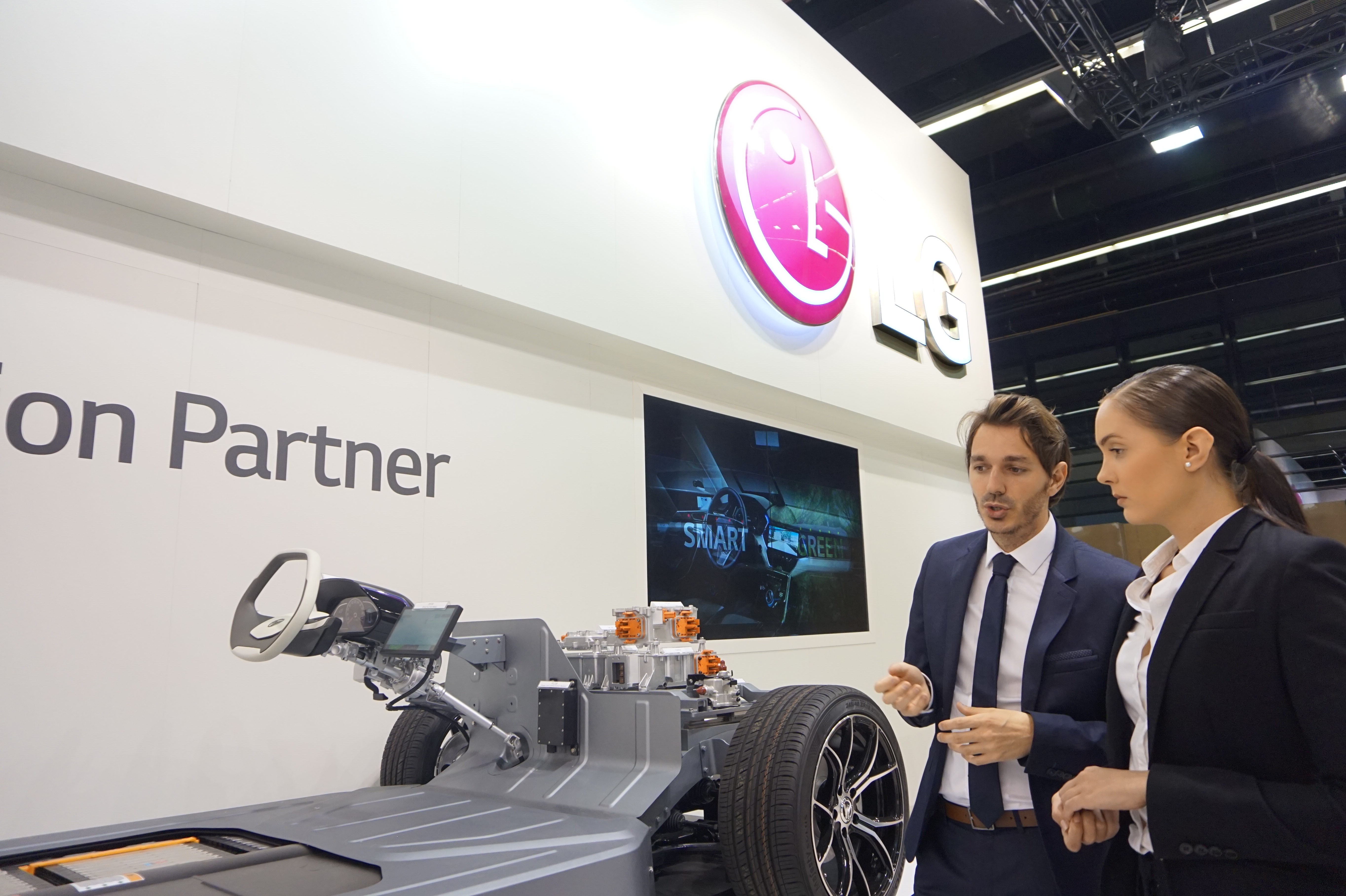 A lady and gentleman discuss LG Vehicle Component technology in front of the LG booth at the Frankfurt Motor Show.