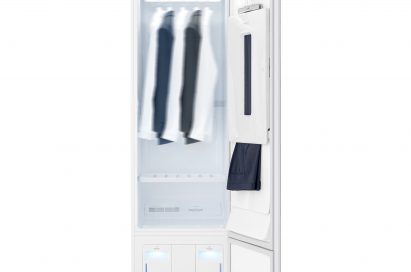 Front view of LG Styler with its door open, showing trousers hanging on the door and a jacket and white shirt hanging inside