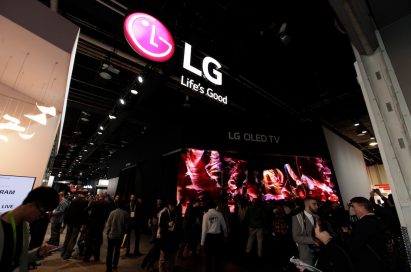 LG’s booth at CES 2018 with visitors in the foreground, the logo and ‘Life’s Good’ slogan above, and an LG OLED TV sign in the background