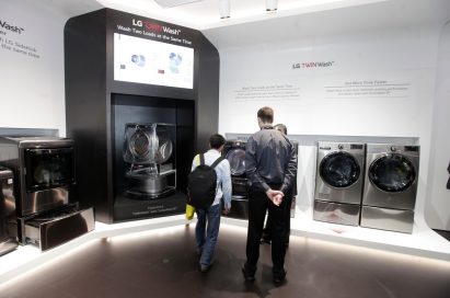 Visitors and an LG representative explore the LG TWINWash zone at CES 2018 together.