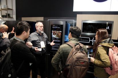 A gentleman explains the main features of the LG InstaView Door-in-Door Refrigerator to three visitors