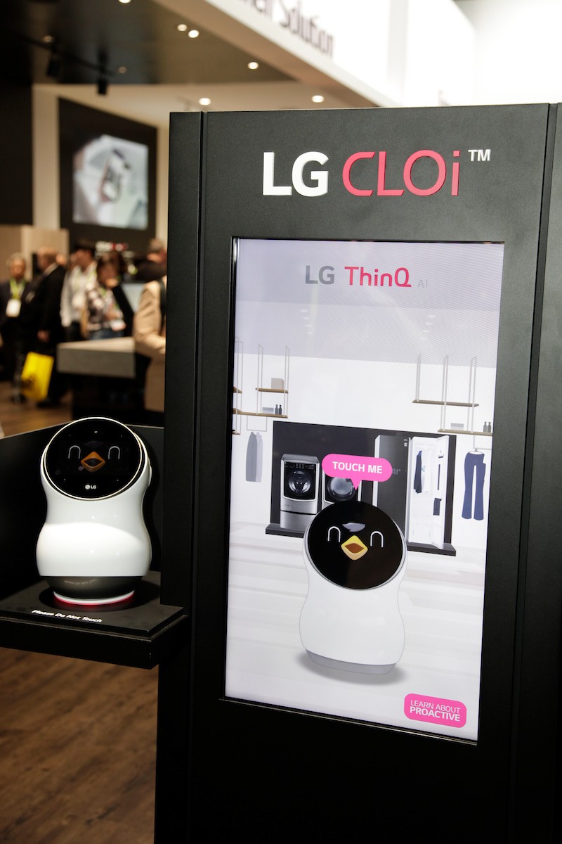 Front view of the LG CLOi Hub Robot and its touchscreen banner that introduces the key features of LG’s ThinQ AI platform and robots