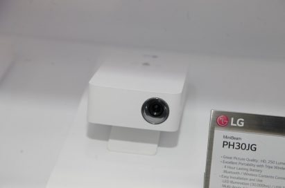 Upper front view of LG’s MiniBeam PH30JG projector placed next to its nameplate