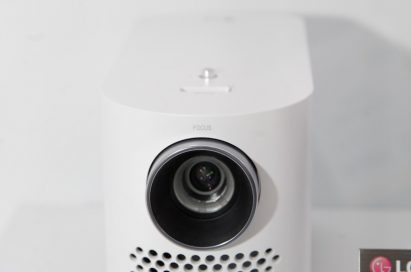 Front view of LG’s ProBeam HF80LG projector placed next to its nameplate