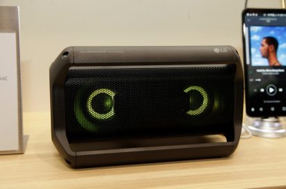 Front view of LG’s Portable Speaker placed next to the company’s smartphone