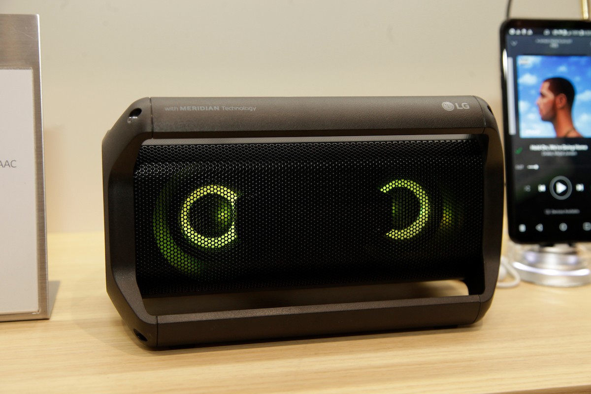 Front view of LG’s Portable Speaker placed next to the company’s smartphone