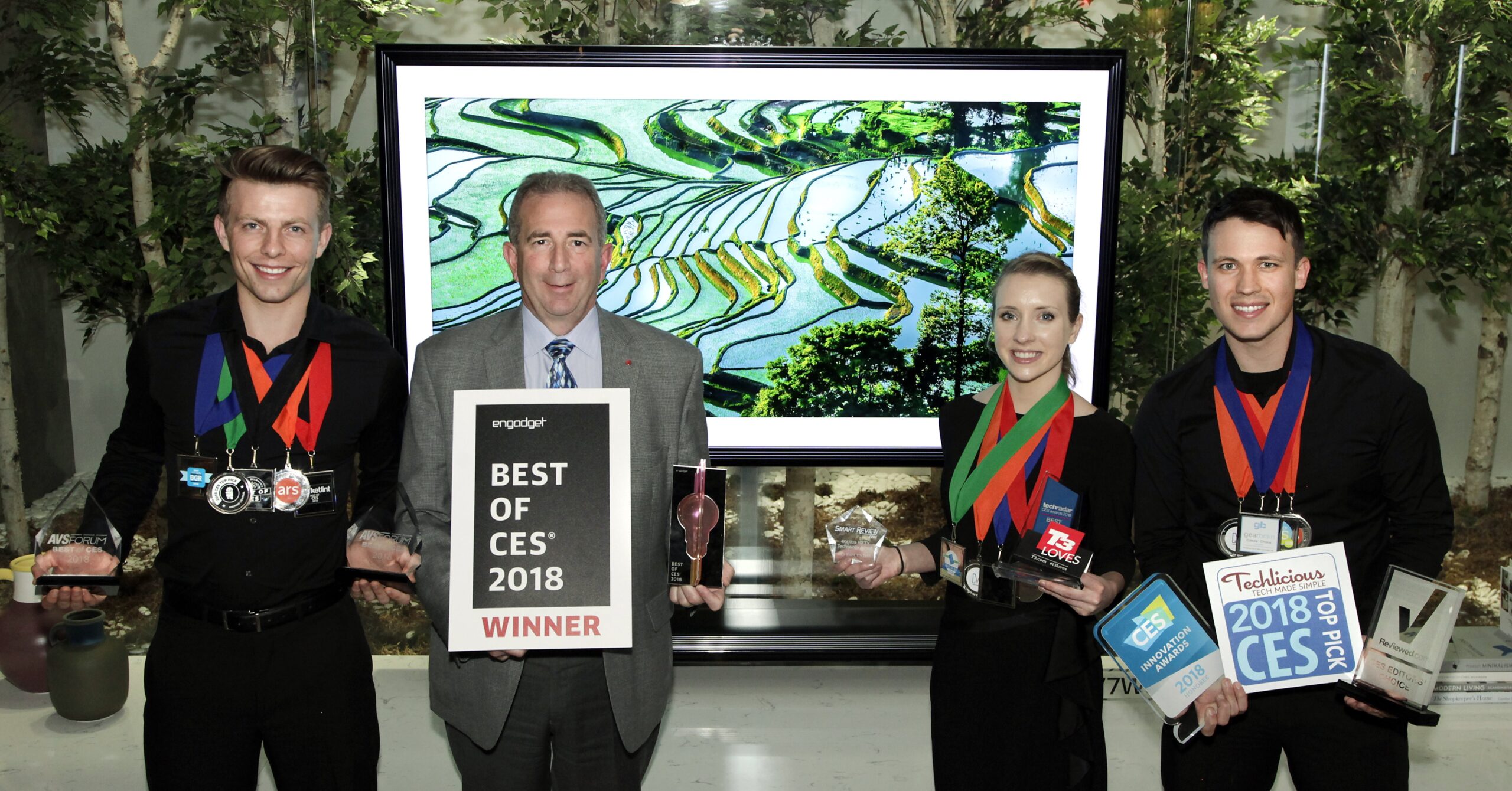 LG Electronics’ USA head of Product Marketing for Home Entertainment Products, Tim Alessi and models pose with awards from Engadget, T3, Techlicious and more, after LG won numerous Best TV product honors at CES 2018.