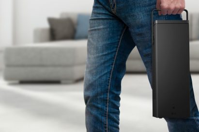 A man carrying the highly portable LG 4K UHD Projector in one hand