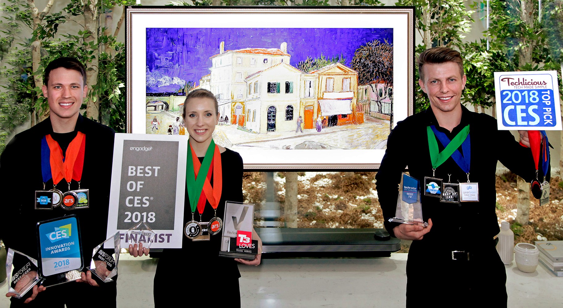 Models pose with the awards from Engadget, T3, Techlicious and more after LG won Best TV product honors at CES 2018.