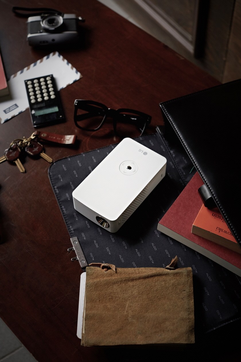 Top view of the LG MiniBeam Projector PH30J on a desk with some items for scale