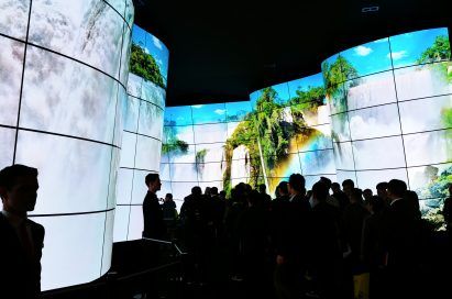 People standing before the entrance of the LG OLED Canyon, which displays a huge waterfall