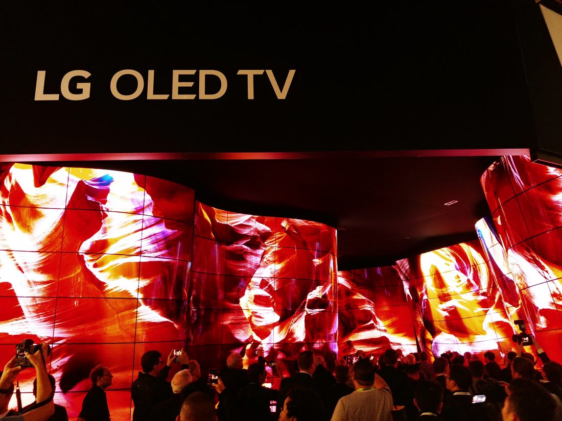 People standing before the entrance of the LG OLED Canyon and taking photos, LG OLED TV sign is visible above the canyon.