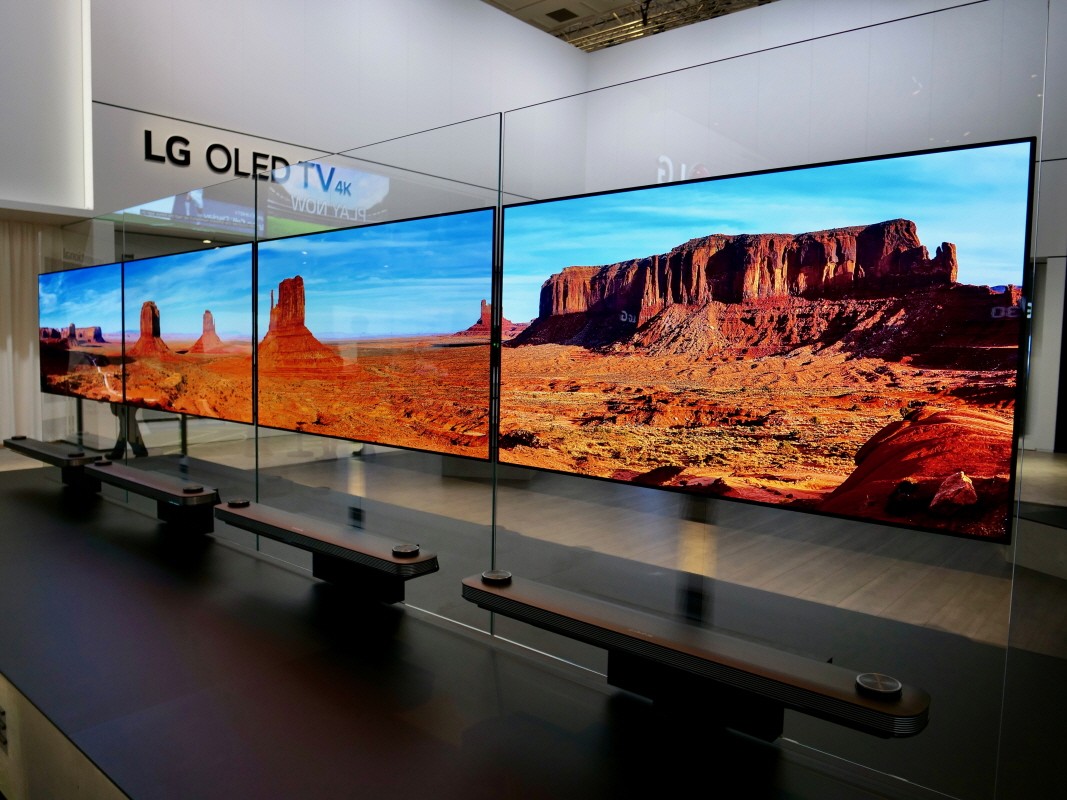 Another view of four LG SIGNATURE OLED TV W sets placed side by side on a display stand at LG's booth